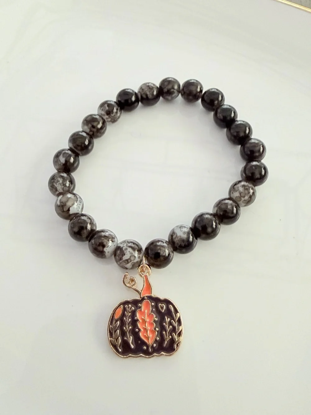 Black and Gray Beaded Bracelet with Orange Pumpkin Charm